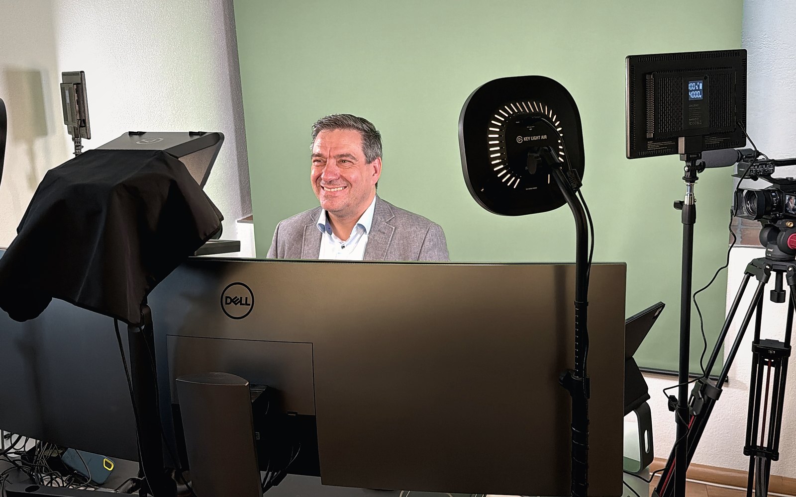 Ralph Kühnl am Pult seines Selbstfahrerstudios mit Teleprompter, Kamera und Licht